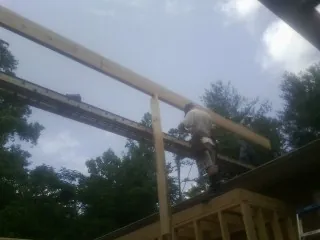 Carpenter setting a ridge beam over a new addition frame — Ice Dam Removal by Roofing Brothers in Wassaic